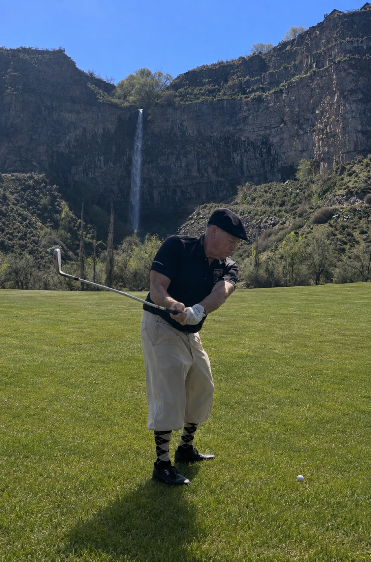 Christopher "Toph" Claunch mid-swing at Canyon Springs Golf Course, with the waterfall and canyon wall behind him